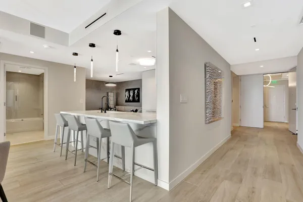 a kitchen with stainless steel appliances kitchen island granite countertop a table chairs sink and cabinets