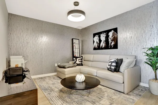 a living room with furniture and a wooden floor