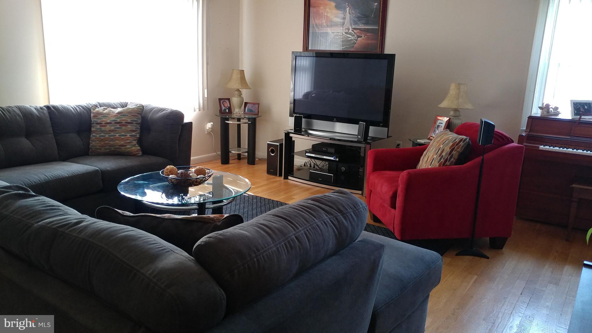 6002 Chesworth Road Baltimore, MD 21228 - Photo 3 of 26 a living room with furniture a fireplace and a flat screen tv