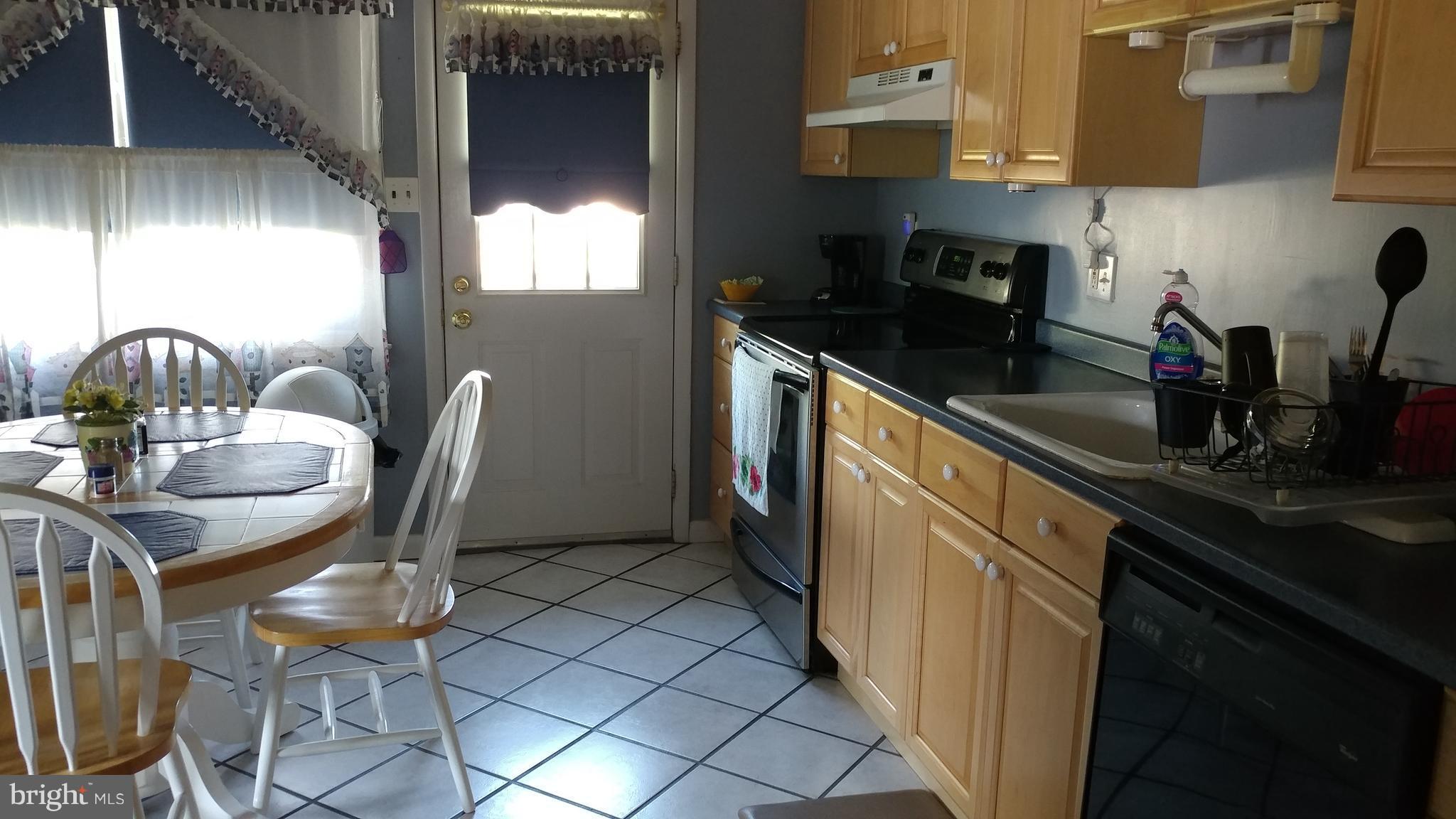 6002 Chesworth Road Baltimore, MD 21228 - Photo 7 of 26 a kitchen with granite countertop cabinets a sink and a stove