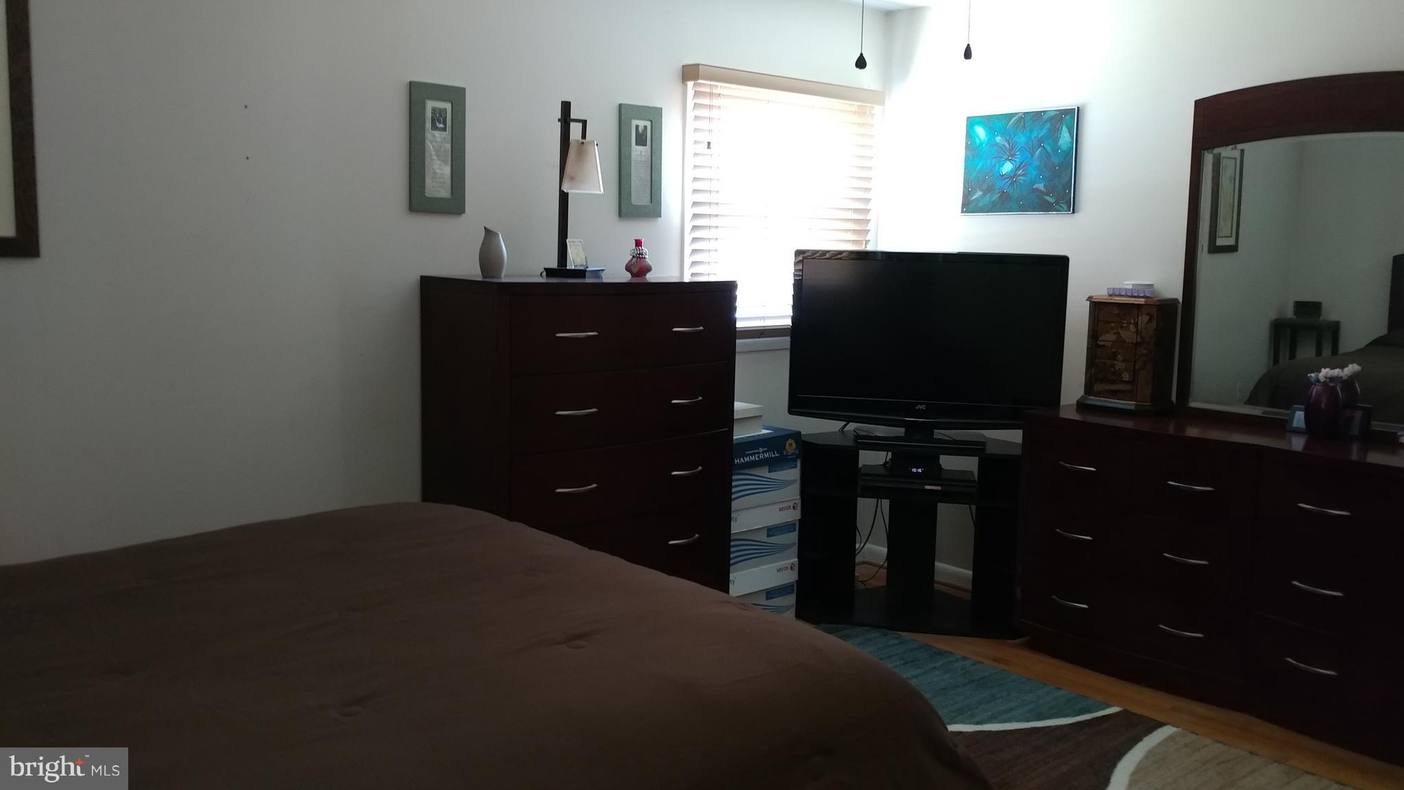 6002 Chesworth Road Baltimore, MD 21228 - Photo 9 of 26 a bedroom with a bed and a flat tv screen on dresser