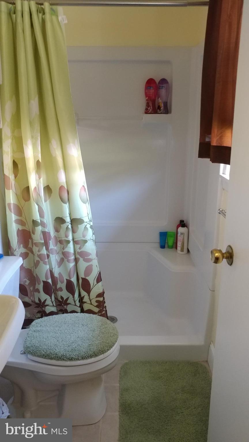 6002 Chesworth Road Baltimore, MD 21228 - Photo 10 of 26 a bathroom with a granite countertop sink a toilet and bathtub
