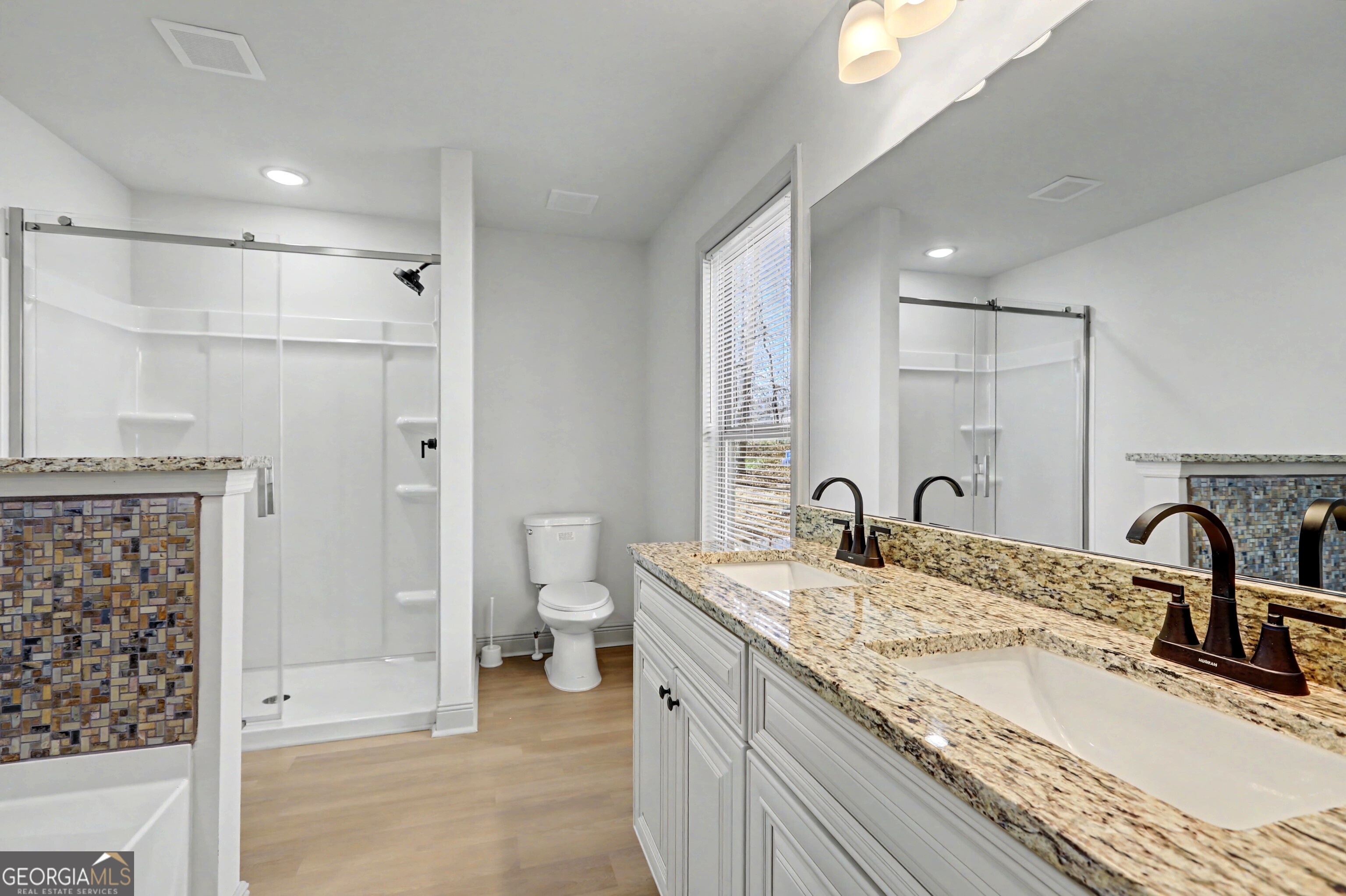 411 Loblolly Ridge Locust Grove, GA 30248 - Photo 15 of 43 a bathroom with a granite countertop sink a toilet and shower