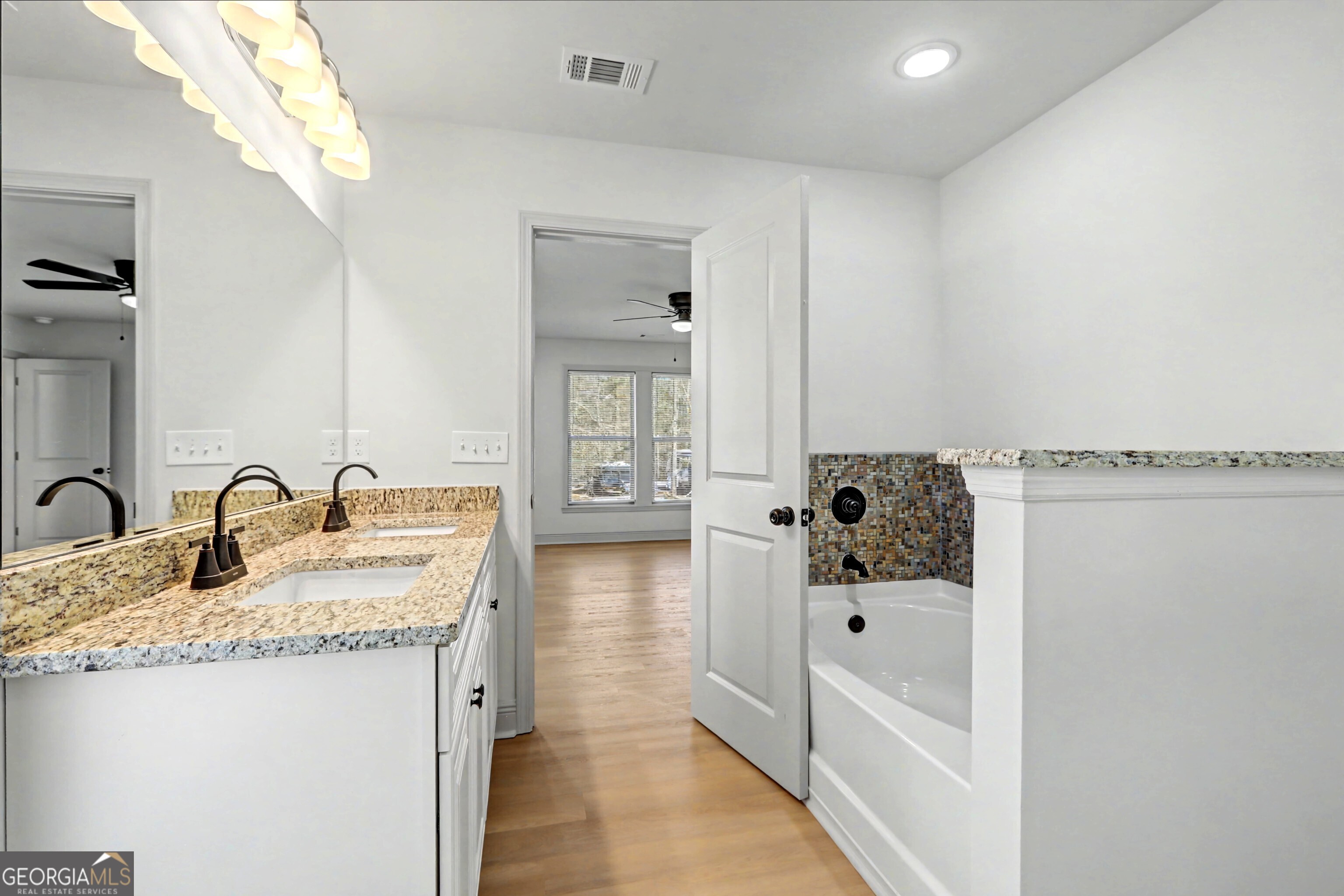 411 Loblolly Ridge Locust Grove, GA 30248 - Photo 17 of 43 a bathroom with a tub sink and mirror
