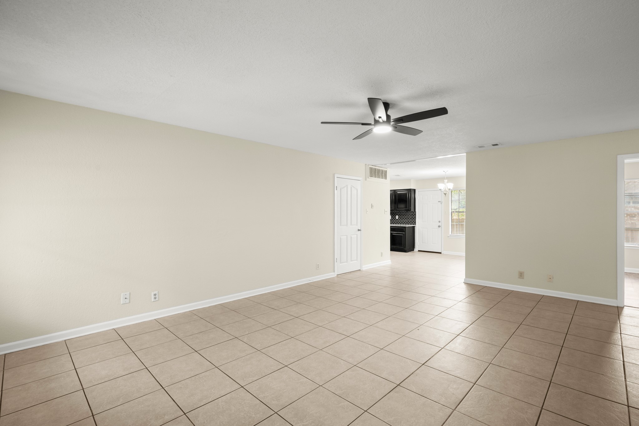 3801 Foust Trail, Unit B Georgetown, TX 78628 - Photo 11 of 31 Spacious living area featuring neutral-toned tile flooring, light-colored walls, and a ceiling fan