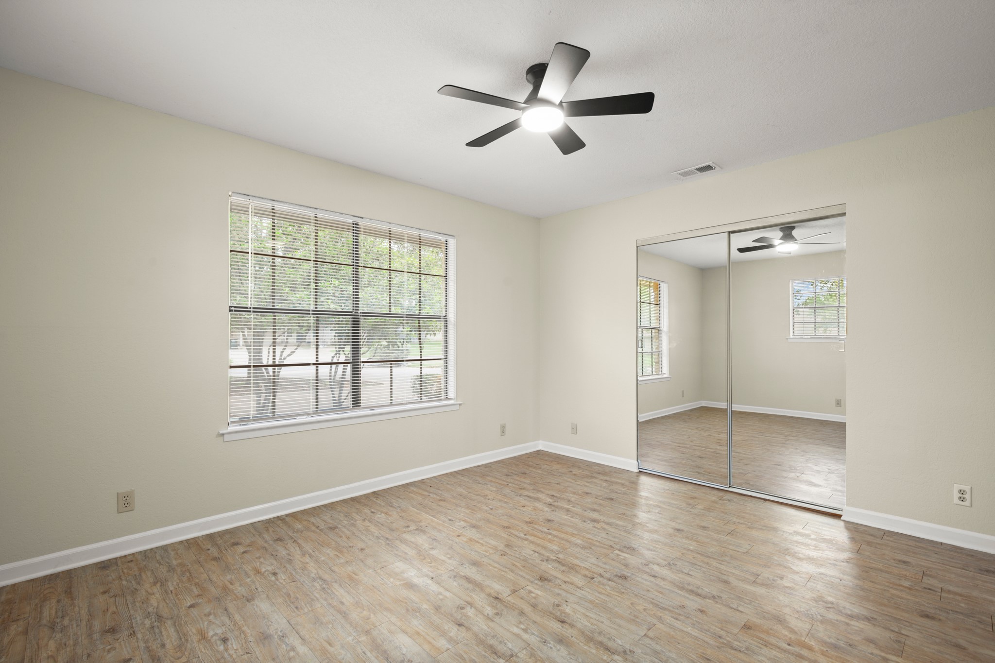 3801 Foust Trail, Unit B Georgetown, TX 78628 - Photo 14 of 31 This room features light-colored walls, wood-style flooring, a window with blinds, and a ceiling fan with integrated lighting
