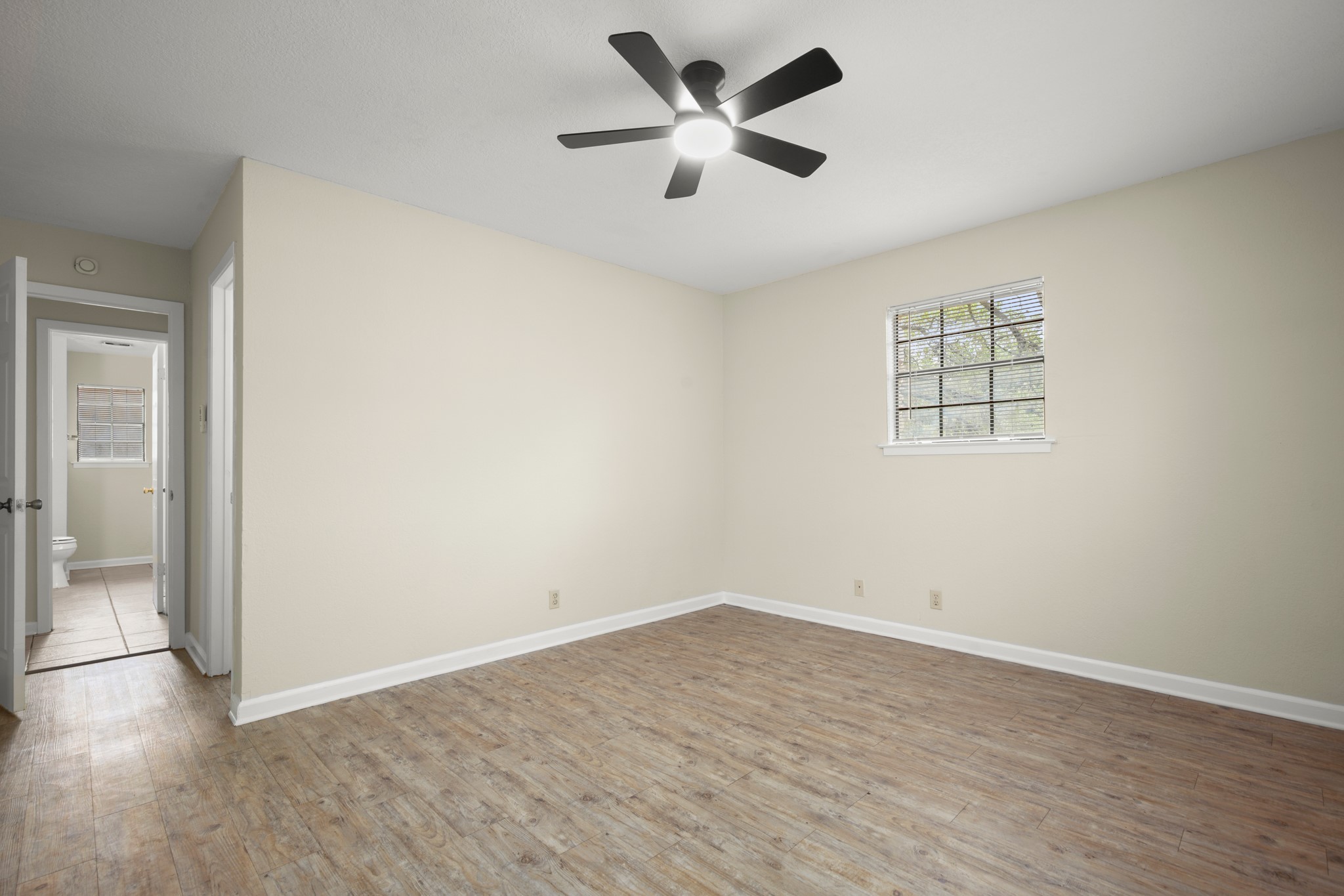 3801 Foust Trail, Unit B Georgetown, TX 78628 - Photo 16 of 31 This room features light-colored walls, wood-style flooring, and a ceiling fan with integrated lighting