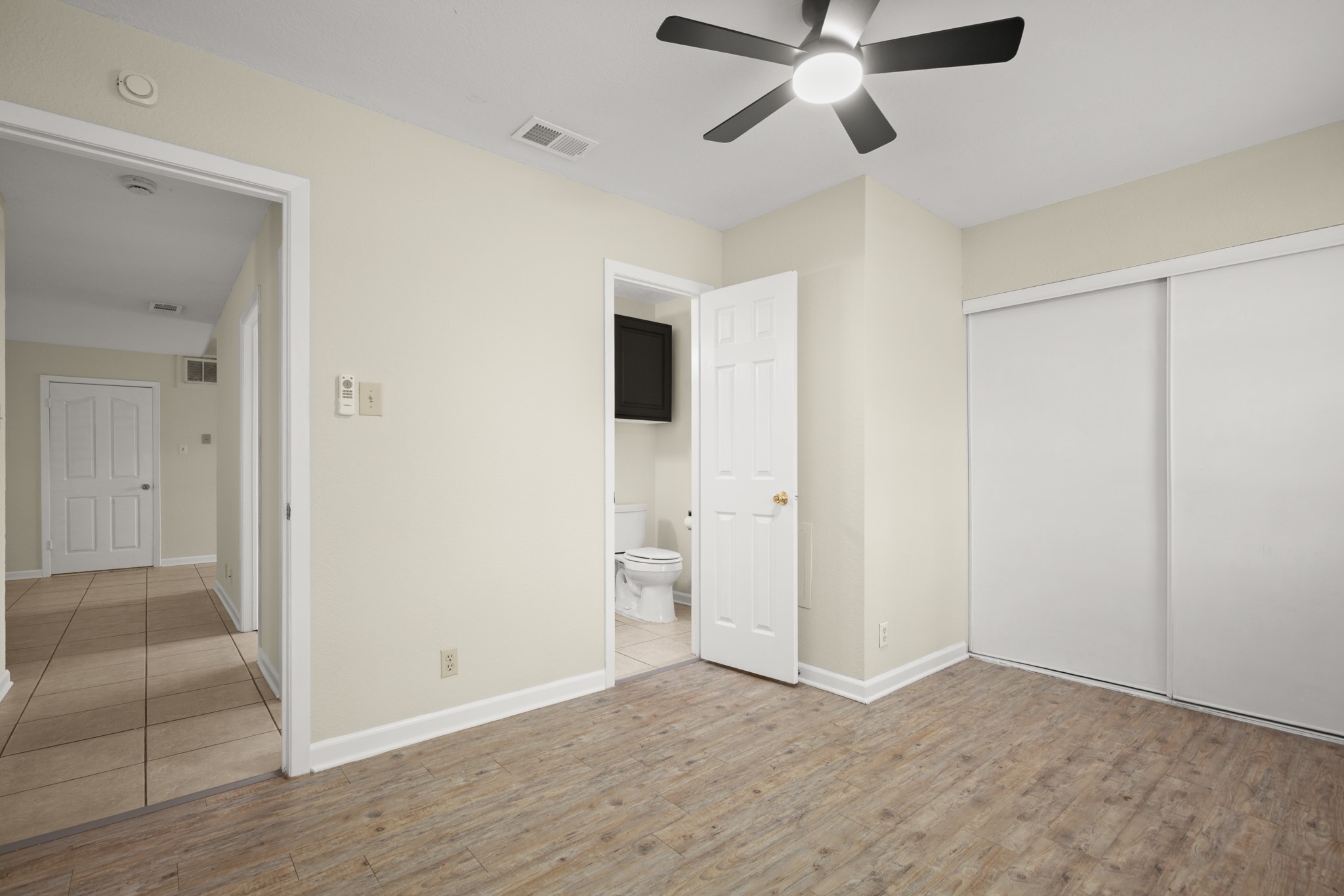 3801 Foust Trail, Unit B Georgetown, TX 78628 - Photo 20 of 31 The property features a room with light-toned flooring, a ceiling fan with integrated lighting, and a white sliding door closet
