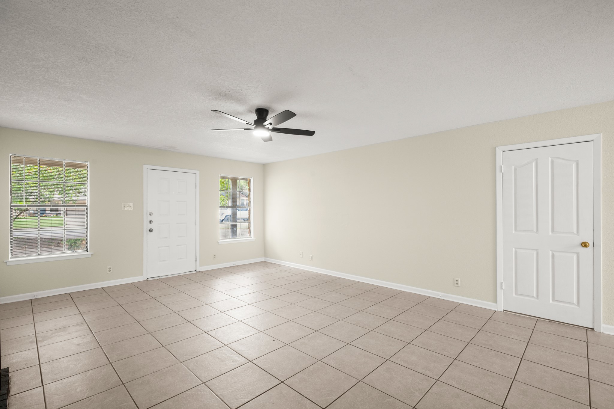 3801 Foust Trail, Unit B Georgetown, TX 78628 - Photo 10 of 31 This bright living area features tile flooring, a ceiling fan with integrated lighting, and two windows providing natural light
