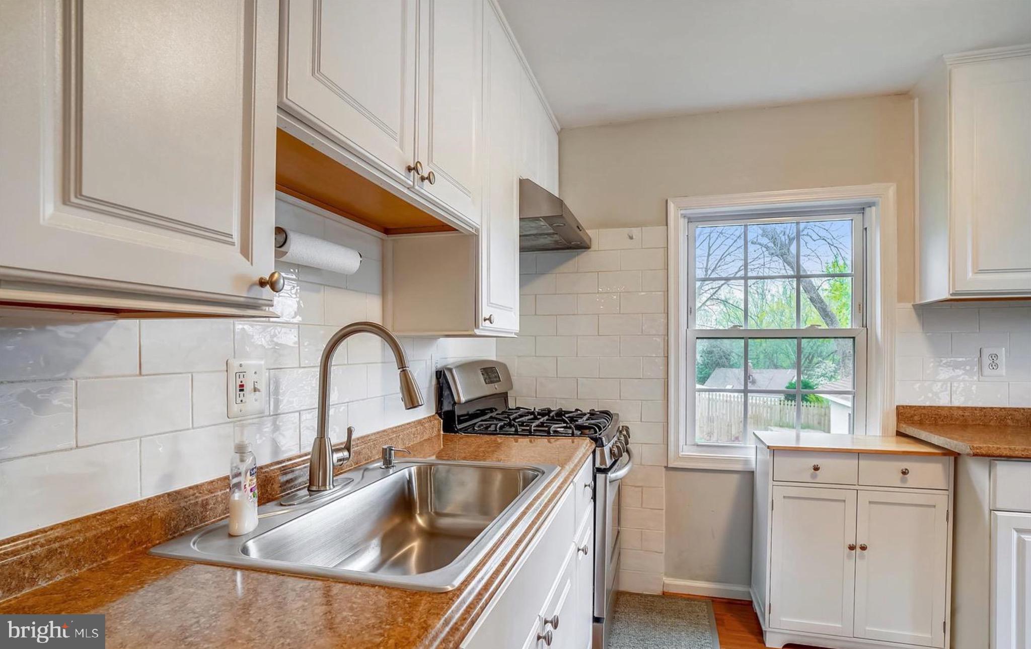 12304 Charles Road Silver Spring, MD 20906 - Photo 4 of 14 a kitchen with stainless steel appliances a sink a stove and cabinets