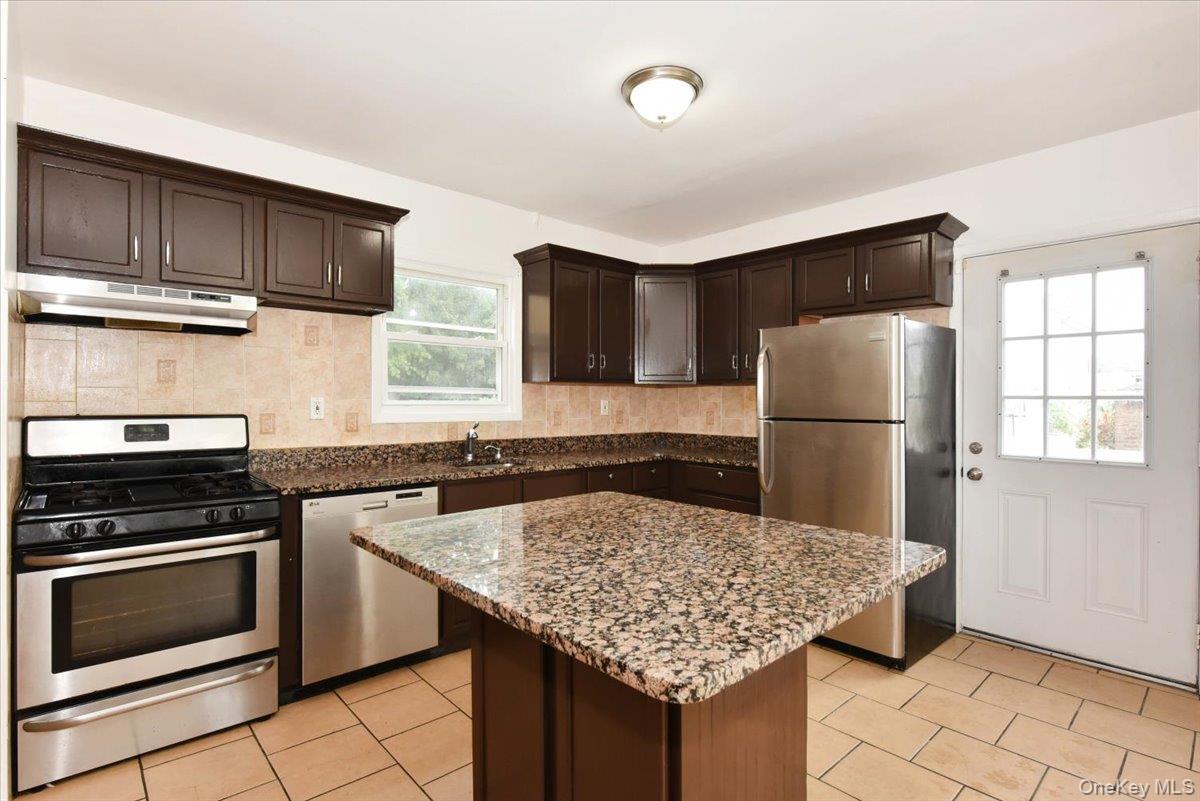 81-35 166th Street Queens, NY 11432 - Photo 12 of 34 a kitchen with stainless steel appliances granite countertop a stove refrigerator sink and microwave