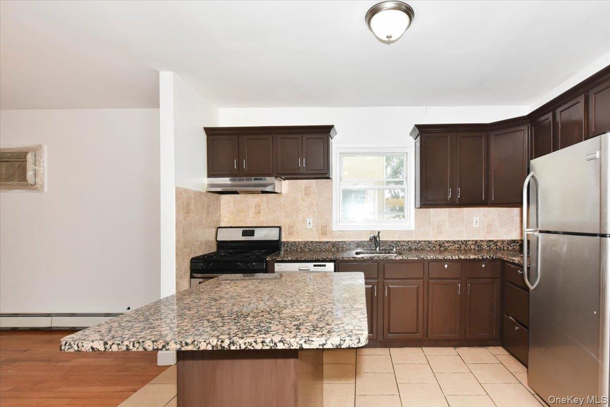 81-35 166th Street Queens, NY 11432 - Photo 13 of 34 a kitchen with stainless steel appliances granite countertop a sink stove and refrigerator