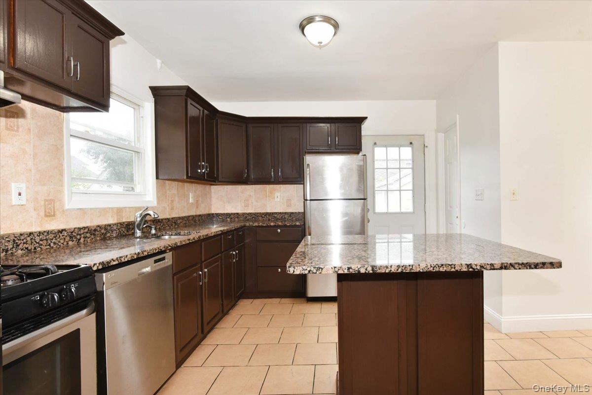 81-35 166th Street Queens, NY 11432 - Photo 15 of 34 a kitchen with granite countertop a sink stainless steel appliances and cabinets
