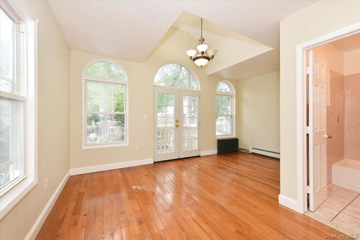 81-35 166th Street Queens, NY 11432 - Photo 19 of 34 a view of an empty room with wooden floor and a window