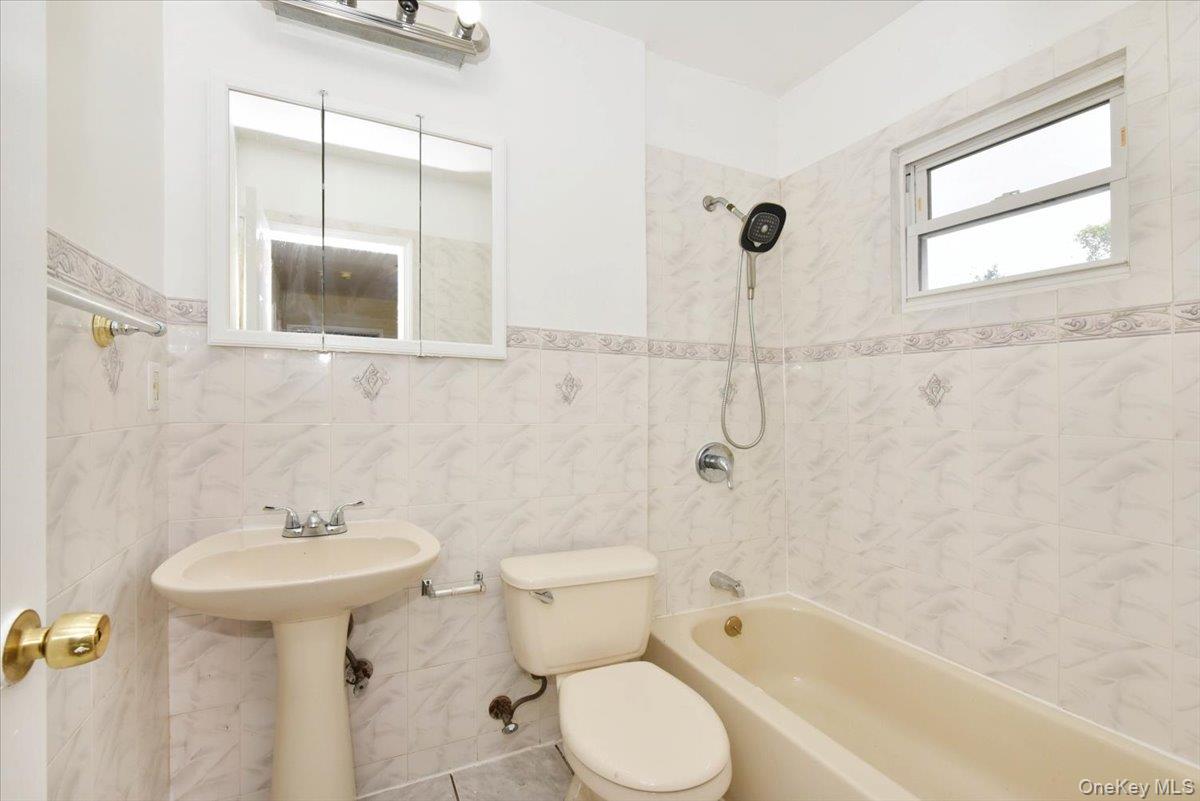81-35 166th Street Queens, NY 11432 - Photo 27 of 34 a bathroom with a sink toilet and shower