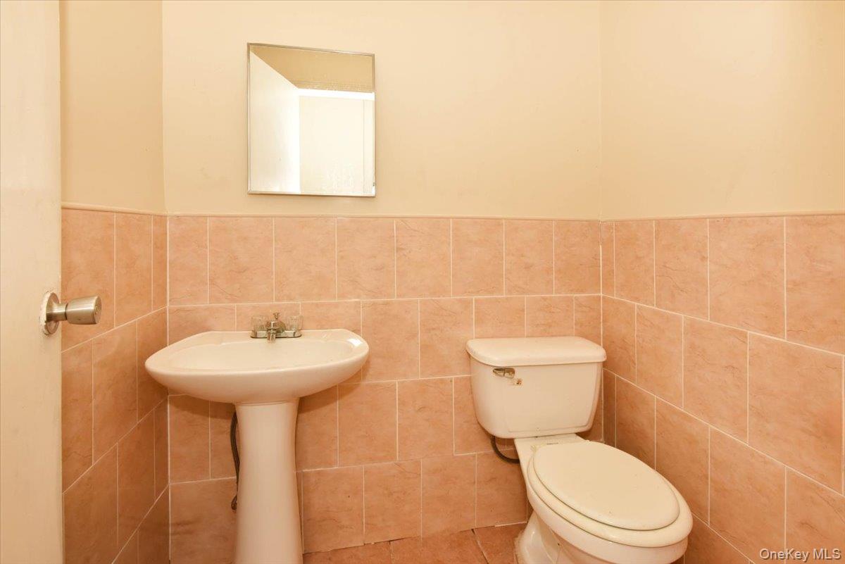 81-35 166th Street Queens, NY 11432 - Photo 31 of 34 a bathroom with a sink a toilet and a mirror