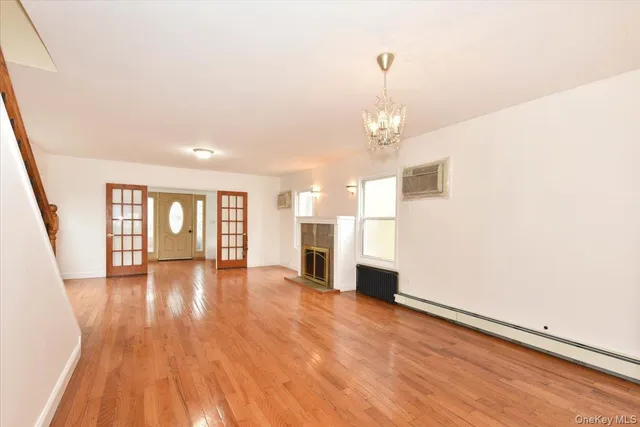 a view of a livingroom with wooden floor and a kitchen