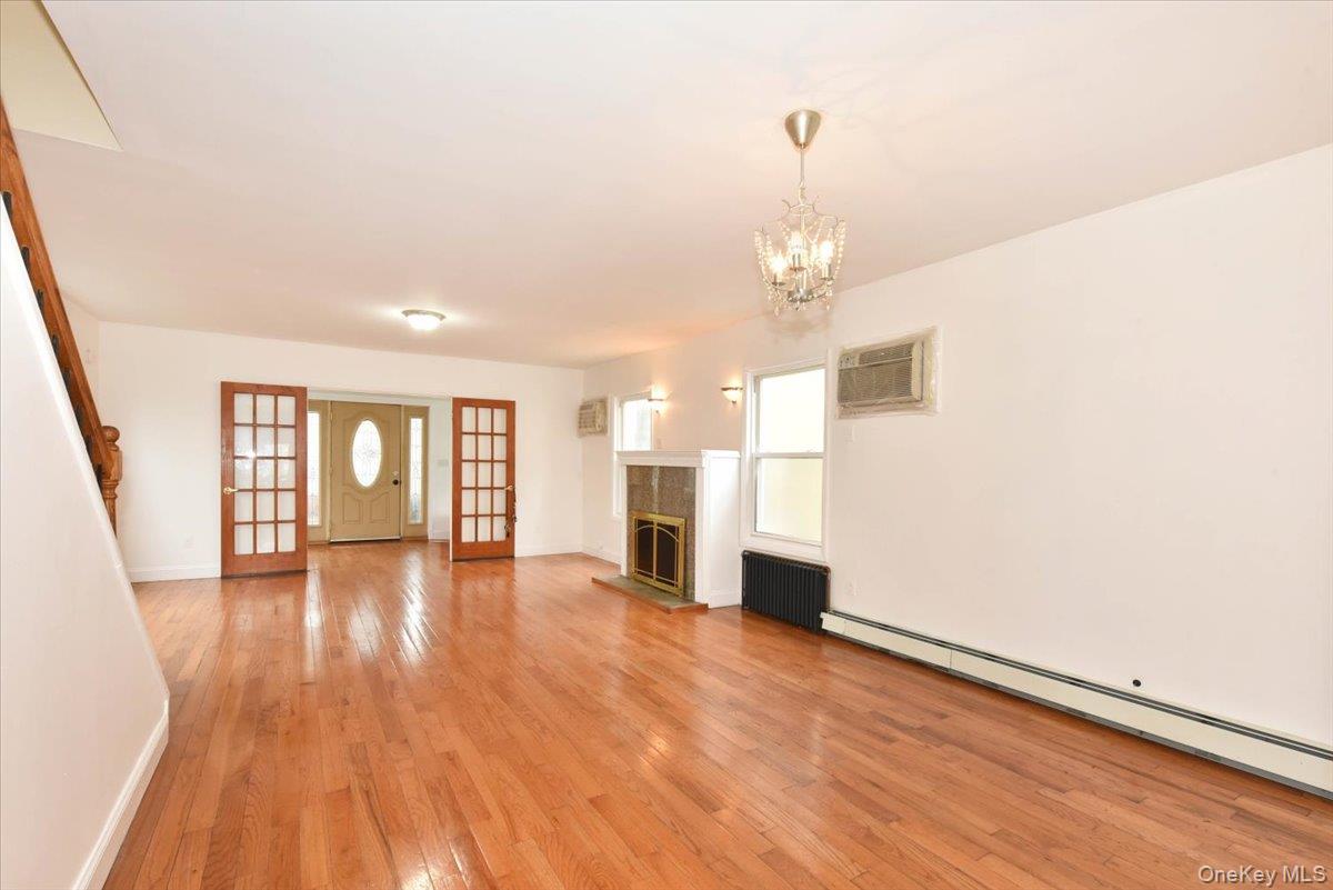 81-35 166th Street Queens, NY 11432 - Photo 6 of 34 a view of a livingroom with wooden floor and a kitchen
