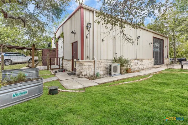 a front view of a house with garden and sitting area