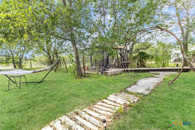 a view of a house with wooden deck and a yard
