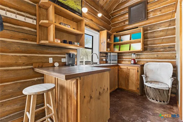 a kitchen with a sink a stove and a dining table with wooden floor