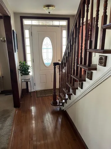 a view of a hallway with wooden floor and staircase