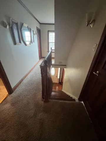 a view of staircase with lots of frames on wall