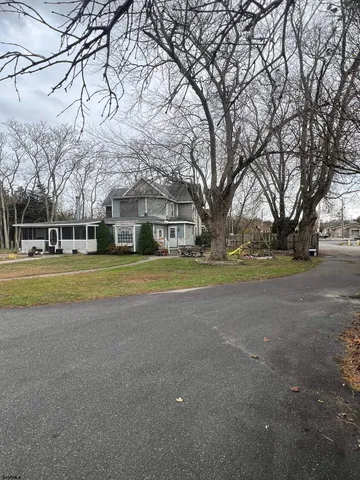 a view of a house with a big yard and large trees