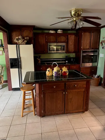 a kitchen with stainless steel appliances granite countertop a refrigerator and a stove top oven