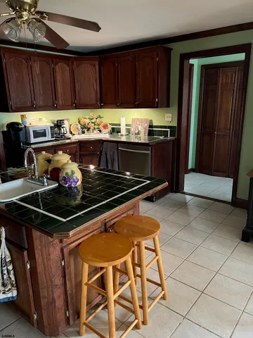 a kitchen with granite countertop a stove top oven a sink and cabinets