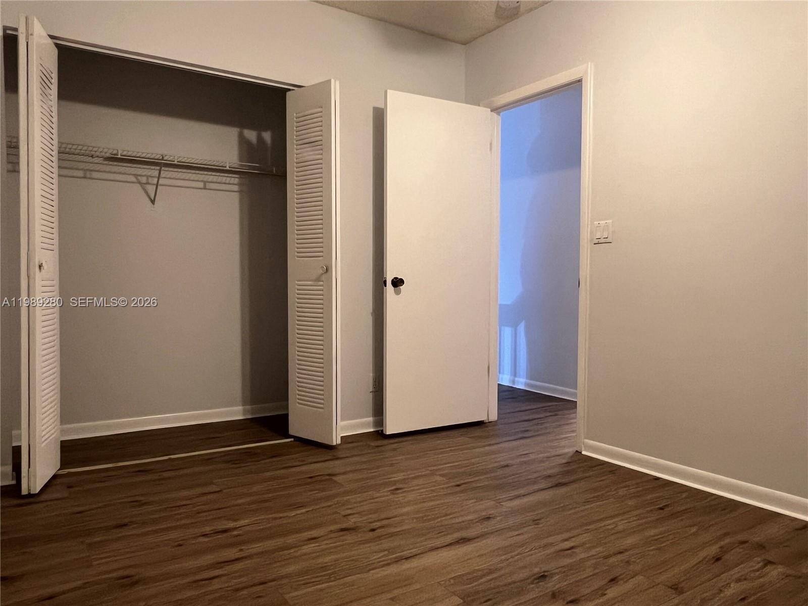 543 Racquet Club Road, Unit 33 Weston, FL 33326 - Photo 27 of 28 an empty room with wooden floor and closet