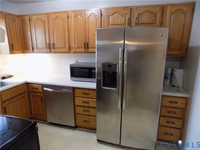 a kitchen with metallic refrigerator and cabinets