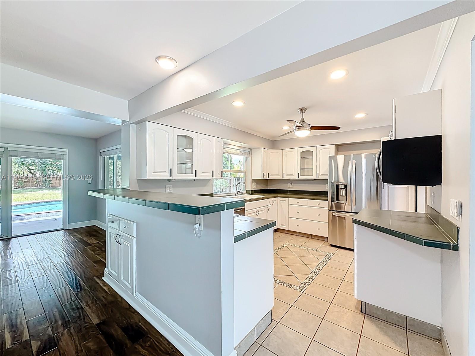 4330 Southwest 7th Street Plantation, FL 33317 - Photo 12 of 57 a kitchen with stainless steel appliances kitchen island granite countertop a sink and cabinets