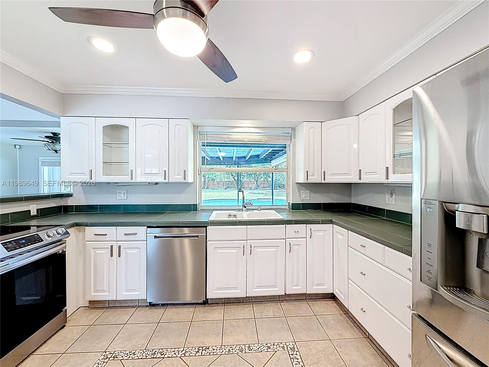 4330 Southwest 7th Street Plantation, FL 33317 - Photo 13 of 57 a kitchen with stainless steel appliances granite countertop a stove a sink and a microwave