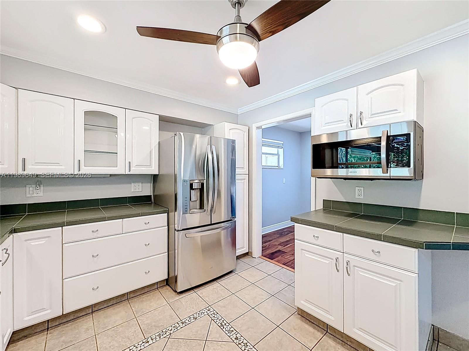 4330 Southwest 7th Street Plantation, FL 33317 - Photo 15 of 57 a kitchen with granite countertop white cabinets and white appliances