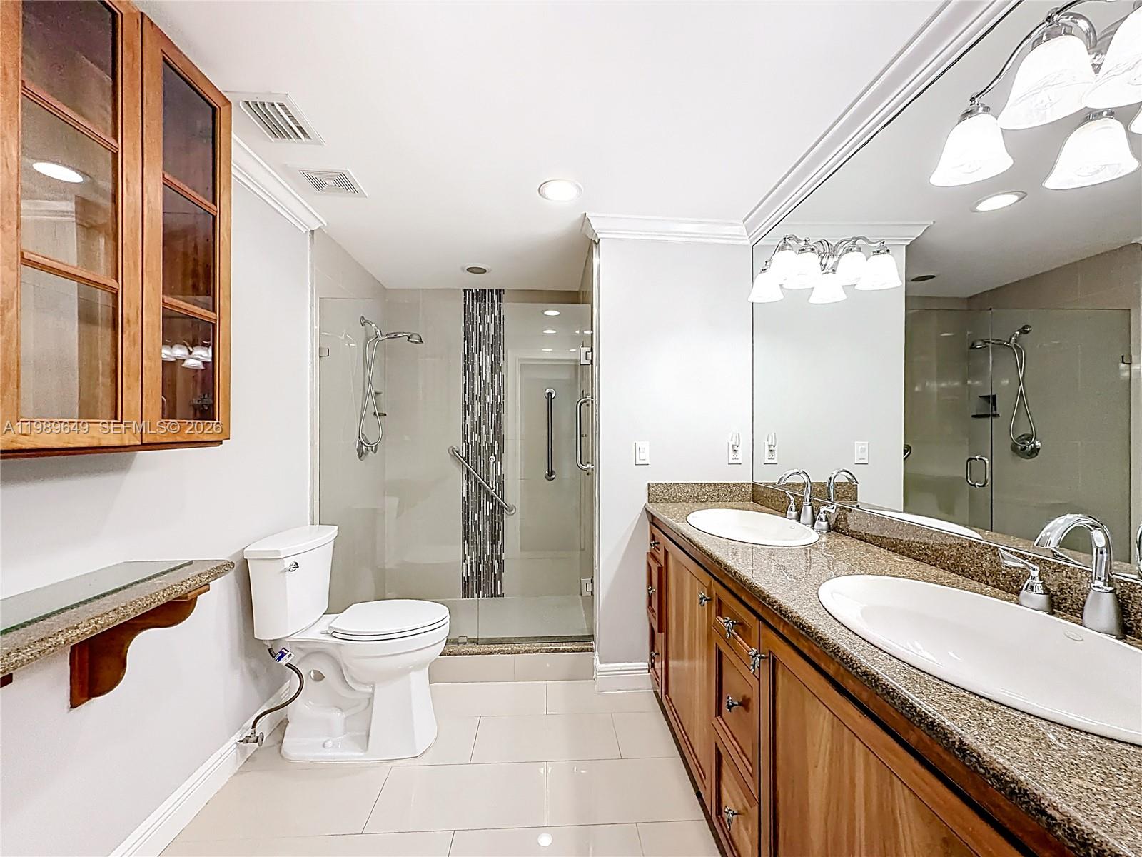 4330 Southwest 7th Street Plantation, FL 33317 - Photo 27 of 57 a spacious bathroom with a granite countertop sink a toilet a mirror and shower