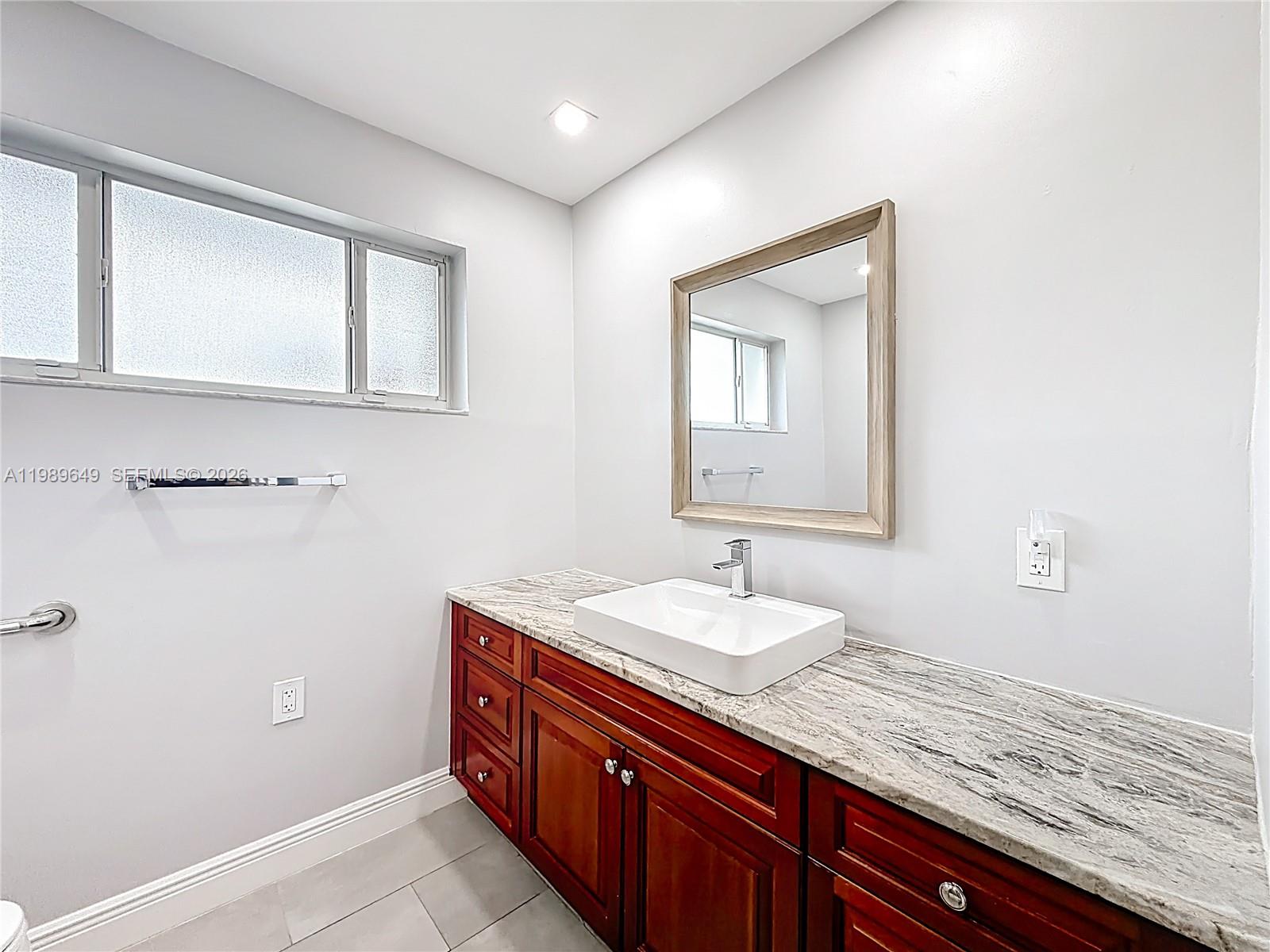 4330 Southwest 7th Street Plantation, FL 33317 - Photo 37 of 57 a bathroom with a granite countertop sink and a mirror