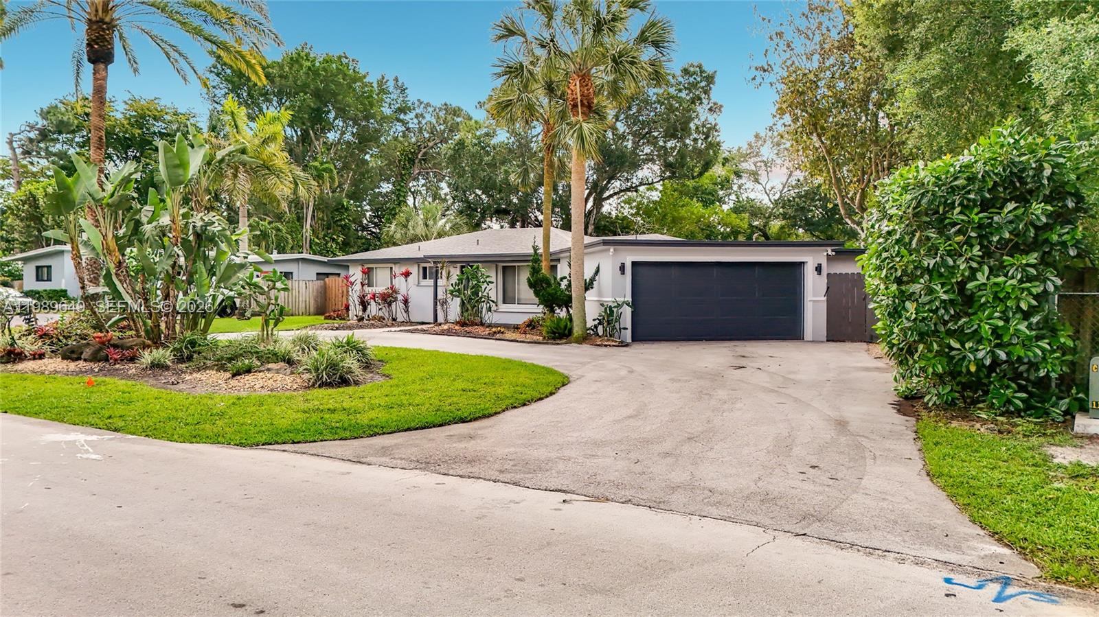 4330 Southwest 7th Street Plantation, FL 33317 - Photo 4 of 57 a front view of a house with a garden and trees
