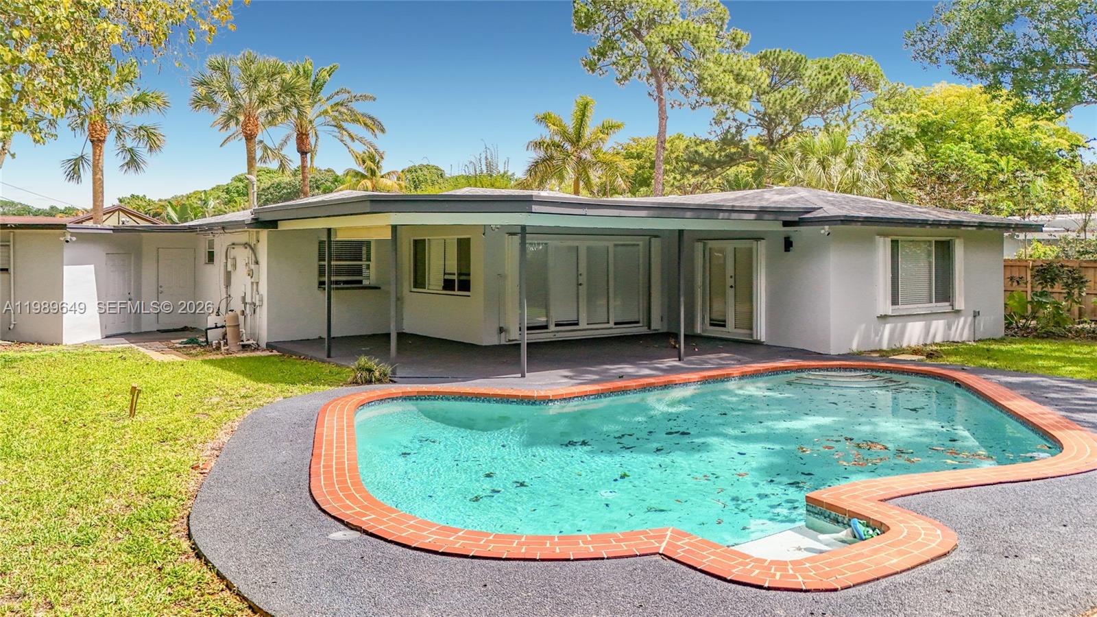 4330 Southwest 7th Street Plantation, FL 33317 - Photo 53 of 57 a view of a white house with a swimming pool and a yard