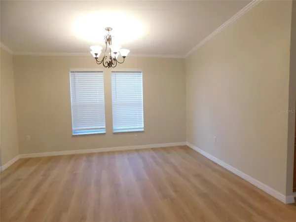 an empty room with a window and wooden floor