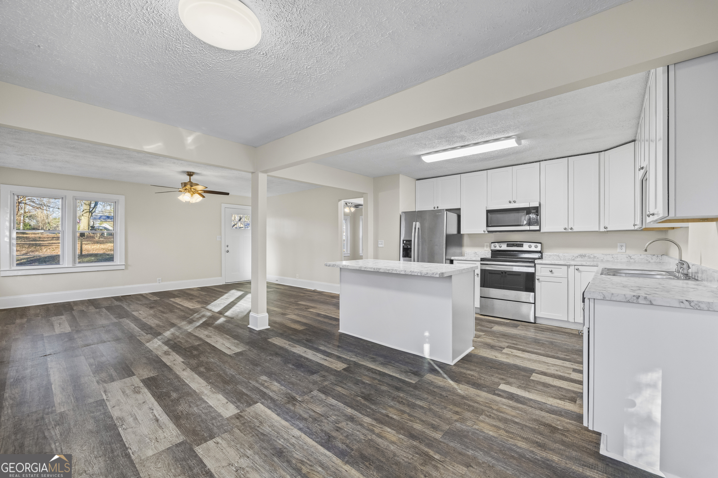 9750 Lavonia Road Carnesville, GA 30521 - Photo 14 of 49 a kitchen with white cabinets and stainless steel appliances