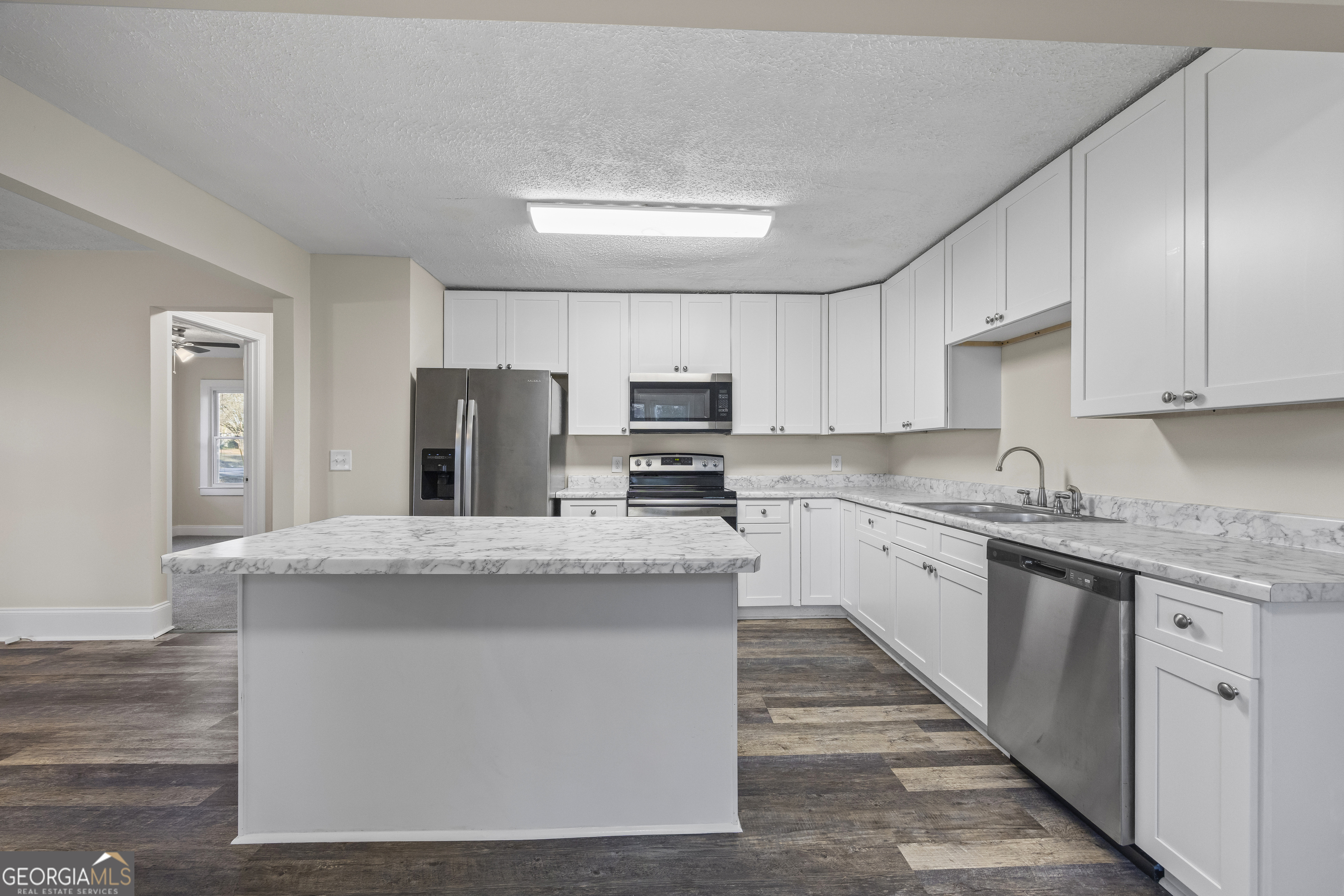 9750 Lavonia Road Carnesville, GA 30521 - Photo 15 of 49 a kitchen with stainless steel appliances granite countertop a stove top oven a refrigerator a sink and dishwasher with wooden floor