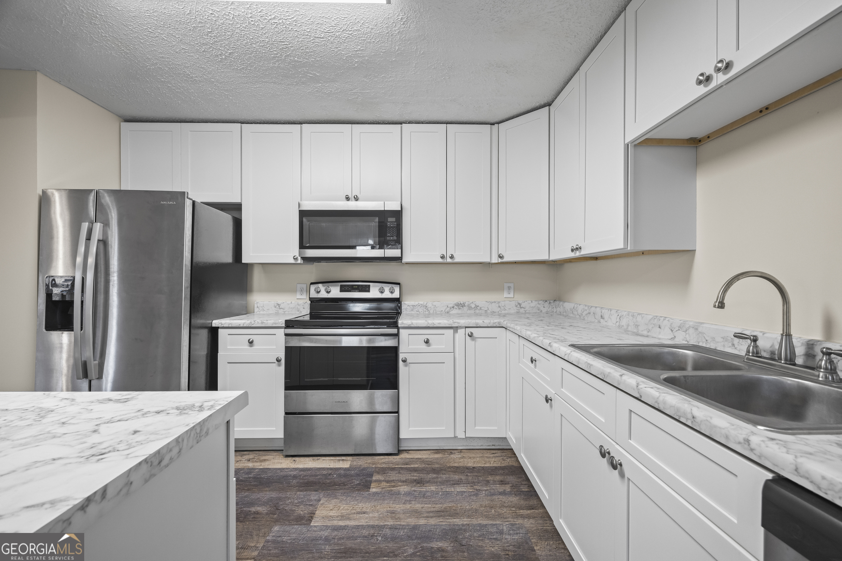 9750 Lavonia Road Carnesville, GA 30521 - Photo 19 of 49 a kitchen with granite countertop white cabinets and stainless steel appliances