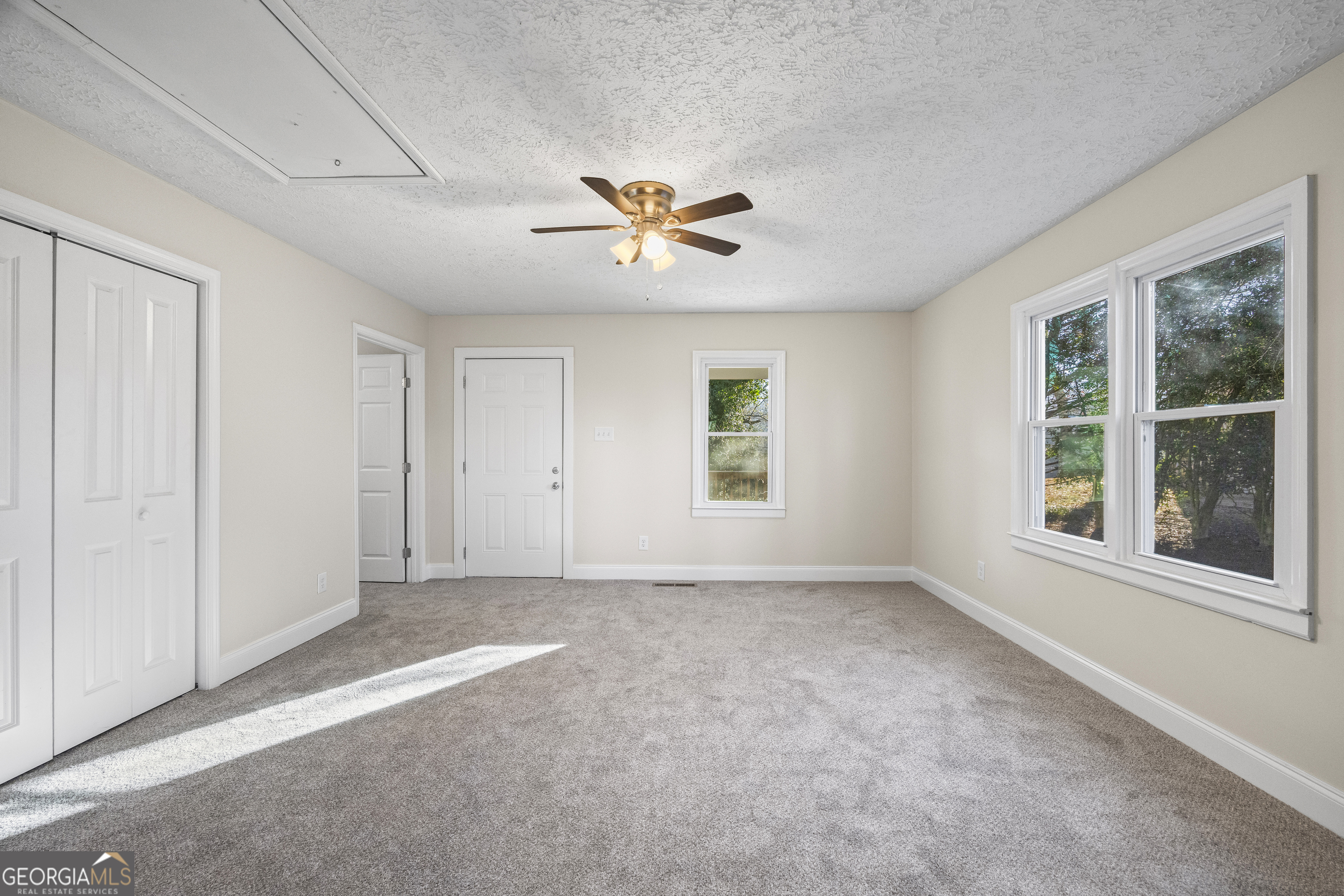 9750 Lavonia Road Carnesville, GA 30521 - Photo 24 of 49 an empty room with windows and fan chandelier fan