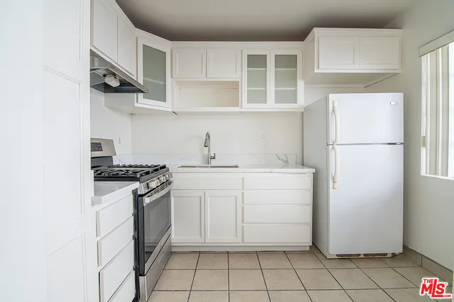 a kitchen with white cabinets and white appliances