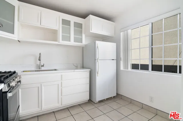 a kitchen with a refrigerator a sink and cabinets