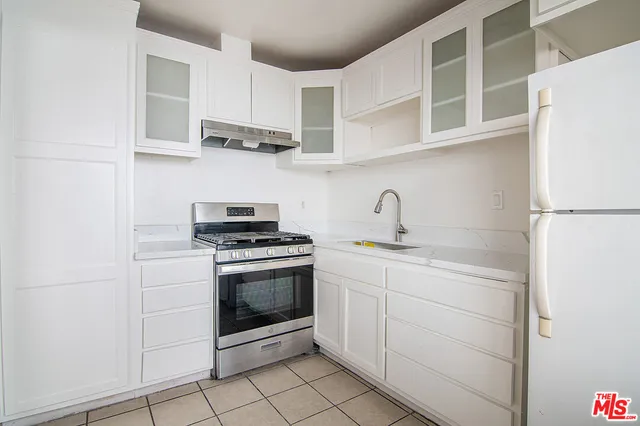 a kitchen with stainless steel appliances granite countertop a sink and a stove