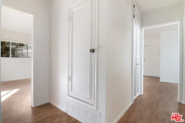 a view of a hallway with wooden floor