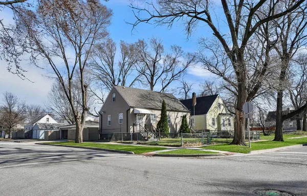 a front view of a house with a yard and large trees