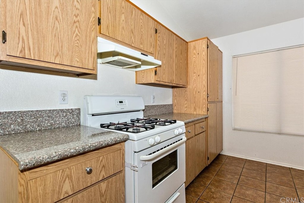 14560 Juniper Lane Adelanto, CA 92301 - Photo 11 of 25 a kitchen with stainless steel appliances granite countertop a stove and a refrigerator